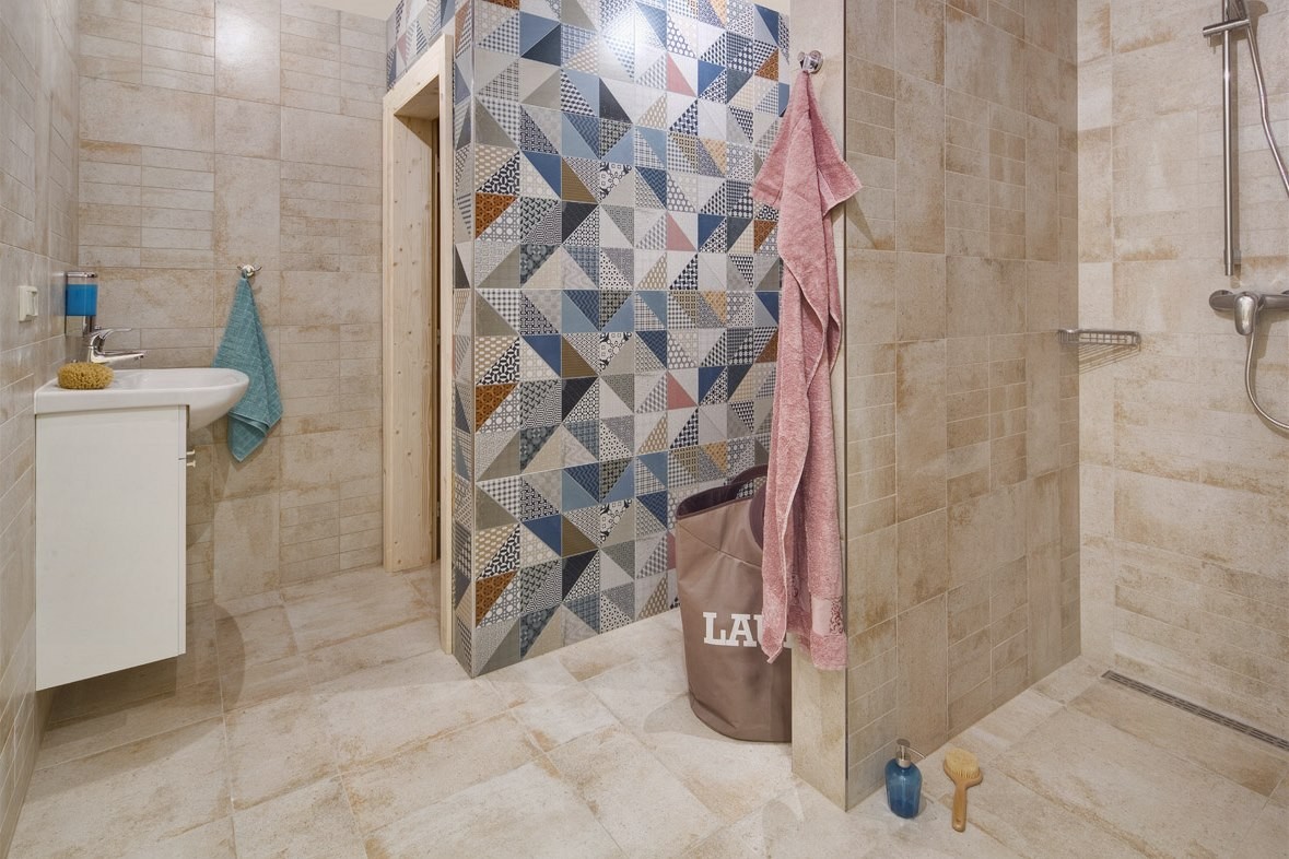 K saune patrí veľká sprcha. V priestore vyniká obklad Deco. Snímka