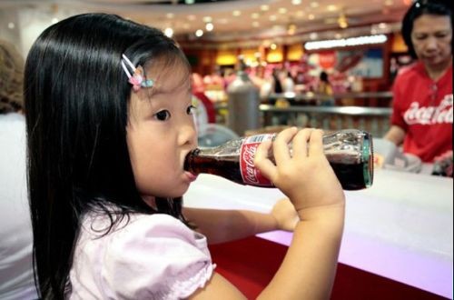Dieťa pije Cocacolu