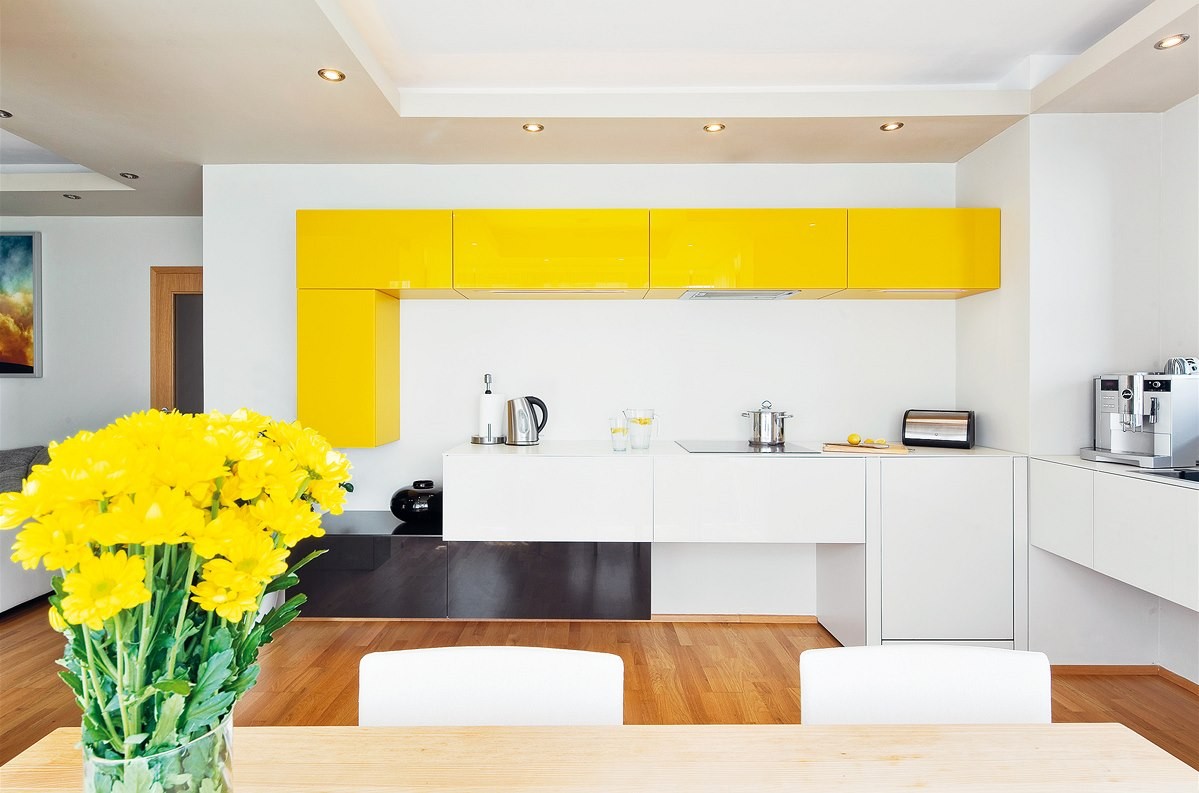 Kuchynská zóna je poskladaná nápadito zo skriniek v troch farbách. Vďaka presklenému výklenku s jedálenským stolom a vzdušnému usporiadaniu je miestnosť veľmi priestranná a svetlá.