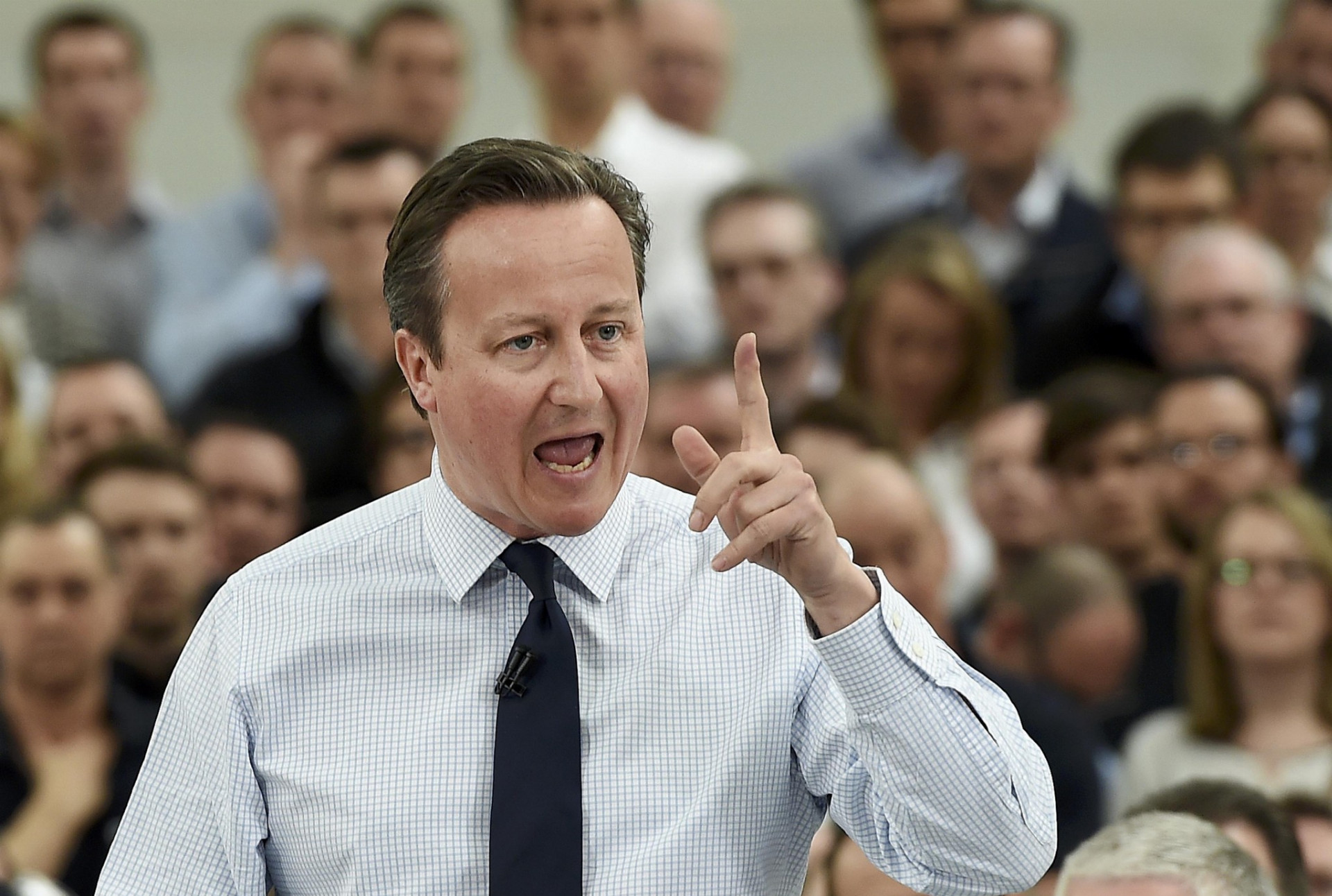 Britský premiér David Cameron hovorí s továrenskými robotníkmi.
