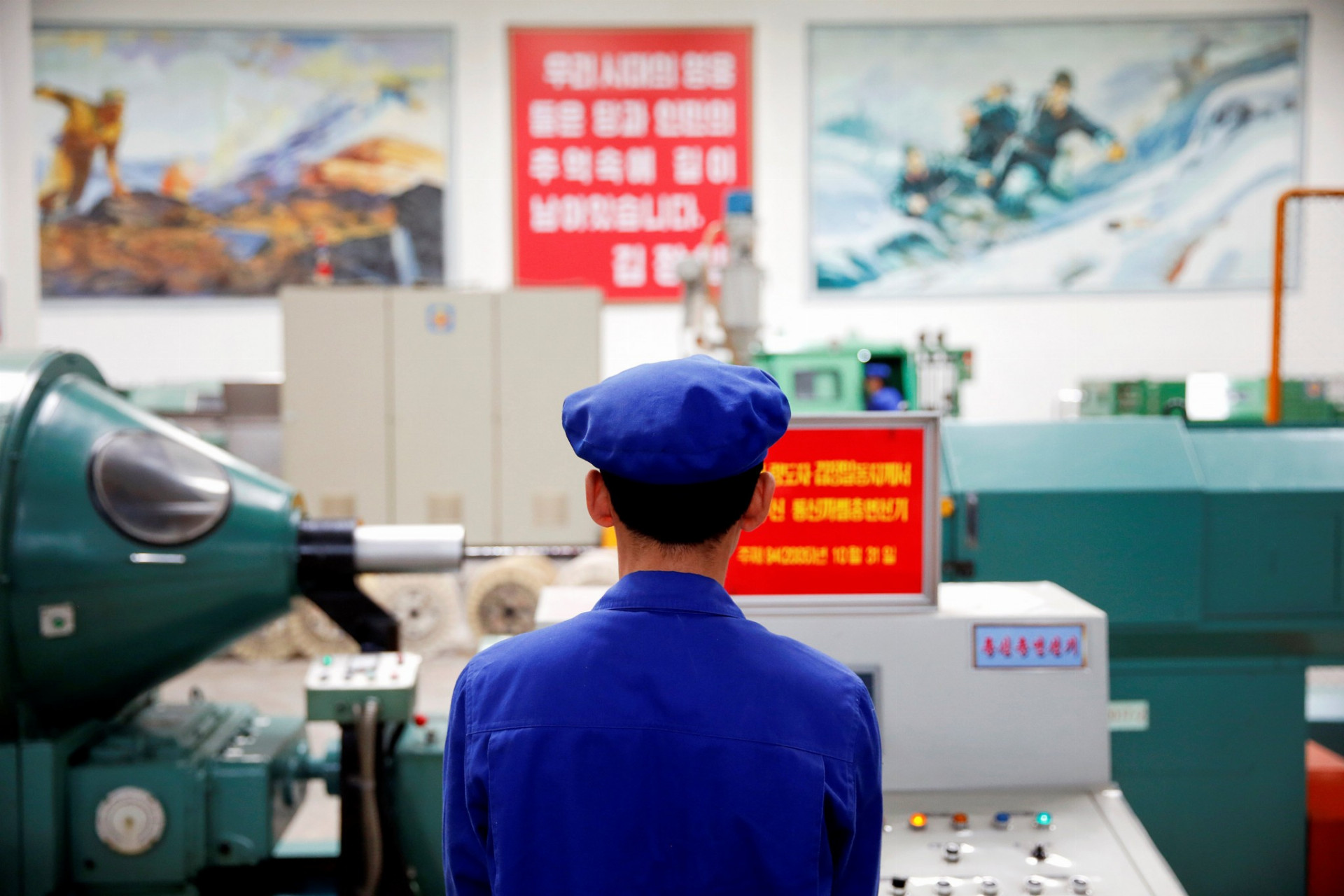Pracovník stojí za strojom počas vládou organizovanej návštevy pre zahraničných reportérov v Pchjongjangu.