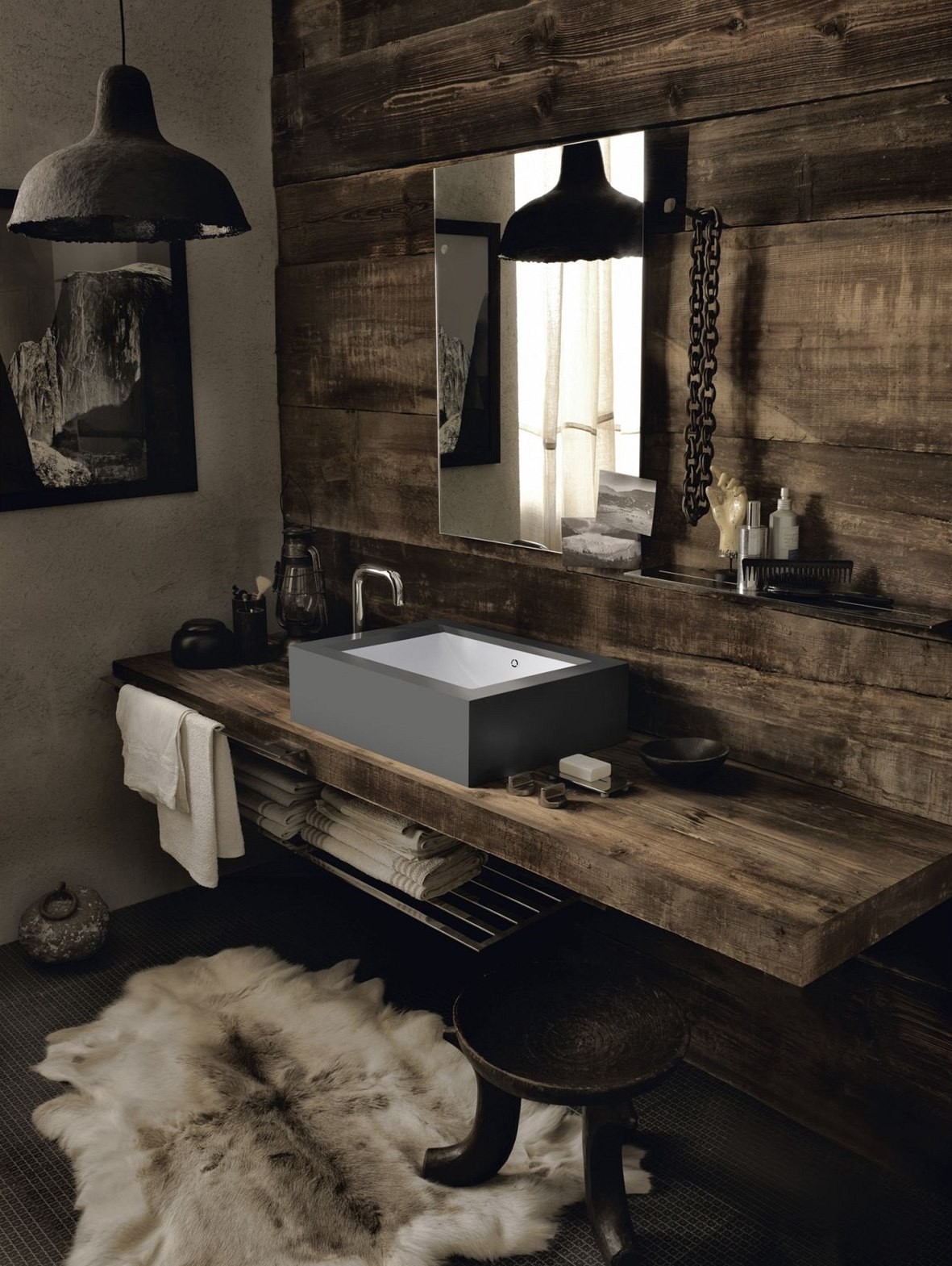 Hrubo pritesaná drevená doska a industriálne šedé umývadlo tvoria v kúpeľni drsnejší dojem. 