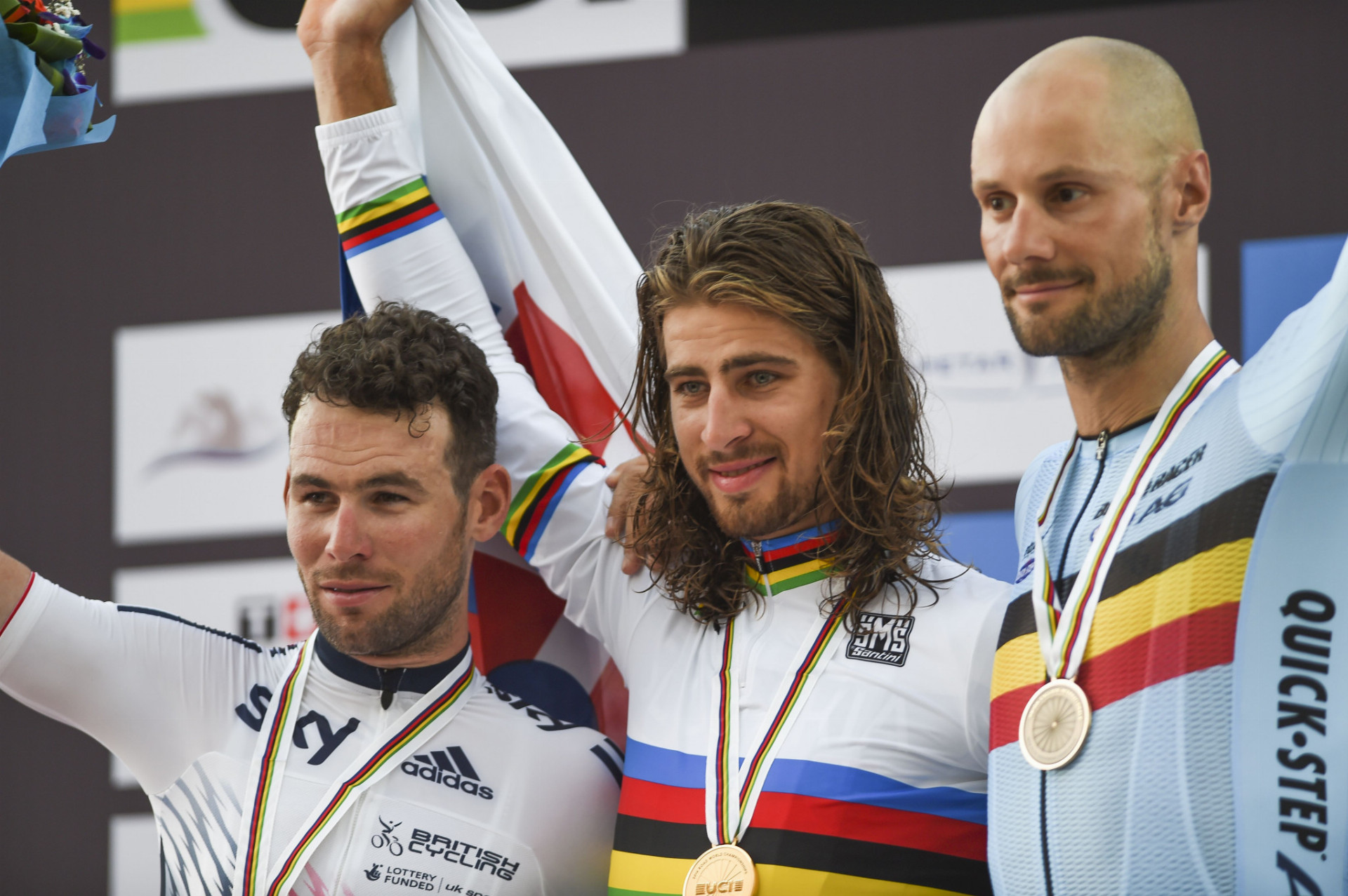  Víťazný slovenský cyklista Peter Sagan (v strede) pózuje na pódiu s druhým Britom Markom Cavendishom (vľavo) a tretím Belgičanom Tomom Boonenom (vpravo) po pretekoch s hromadným štartom mužov elite na 257,5-kilometrovej trati na MS v cyklistike v katarskej Dauhe 16. októbra 2016.
