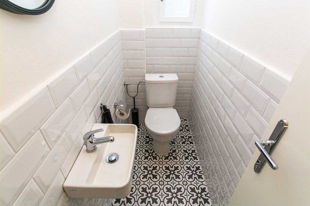 Biele obklady na WC aj výrazná dlažba na podlahe evokujú štýl prvej republiky.