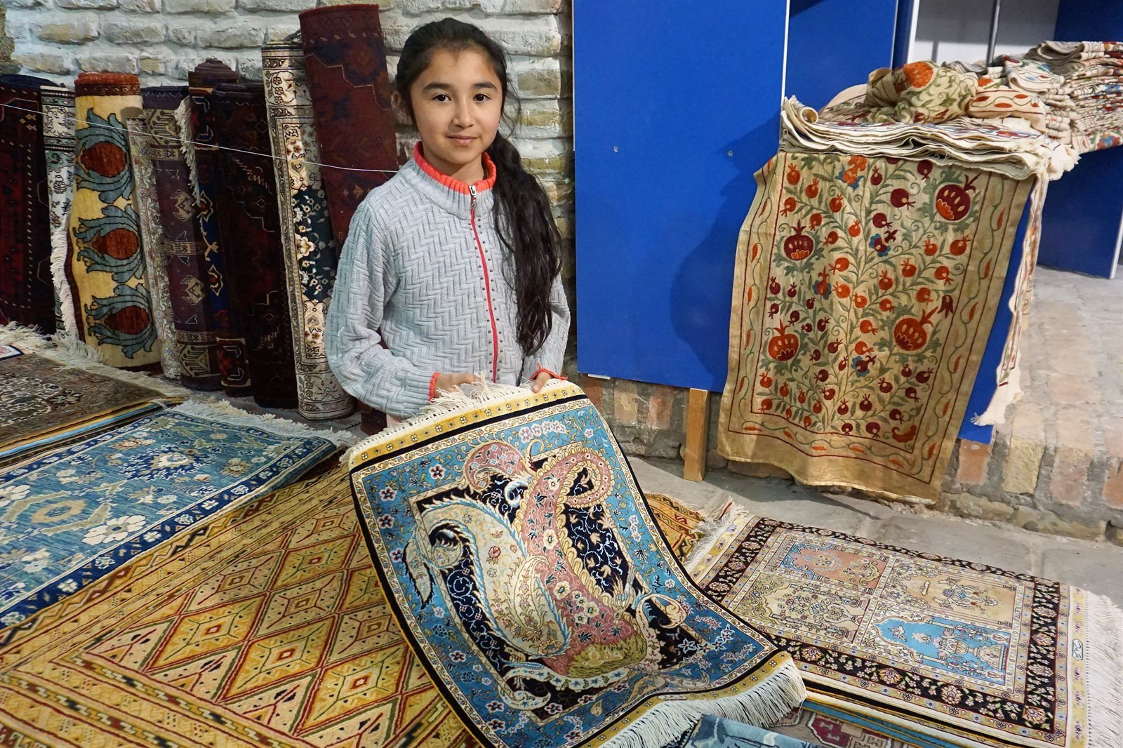 V Uzbekistane sme si obľúbili trhy, kde sa dali zohnať všemožné druhy tovaru. Toto dievčatko predávalo koberce. My sme si žiadny nekúpili, pretože už aj tak máme veľa vecí a domov je ešte ďaleko.