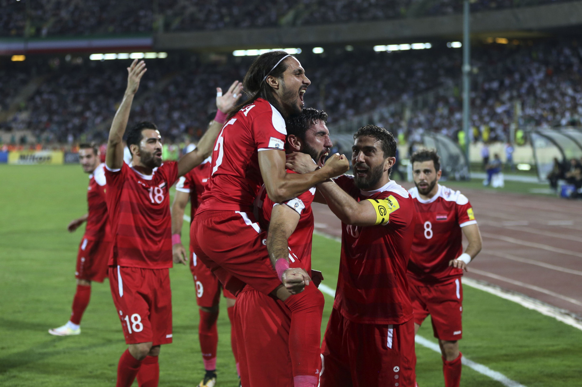 Sýrski futbalisti sa radujú po zásahu do bránky Iránu.