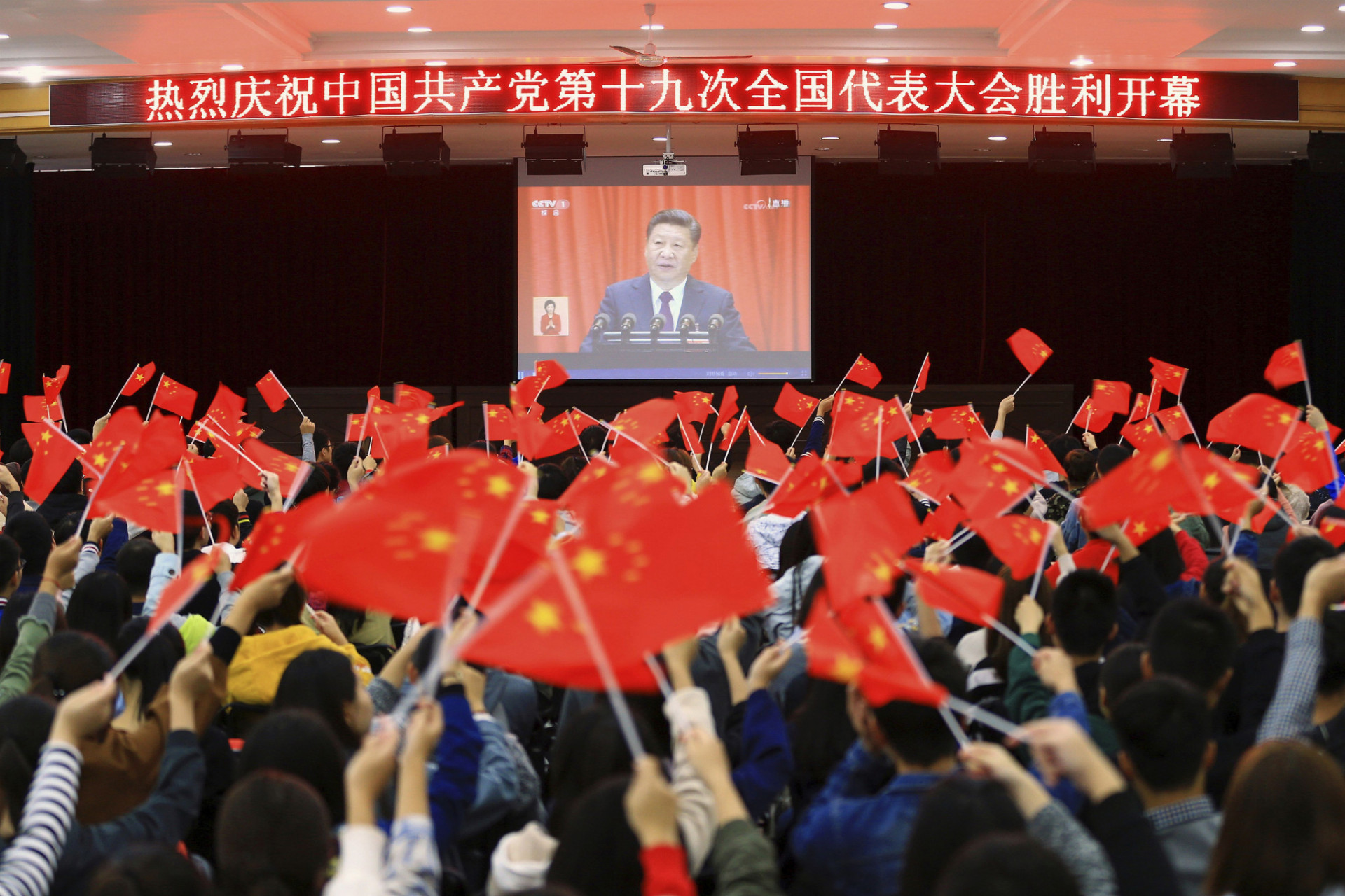 Čínski školáci z prefektúry Chuaj-pej mávali vlajkami počas televízneho prenosu vystúpenia prezidenta Si Ťin-pchinga.