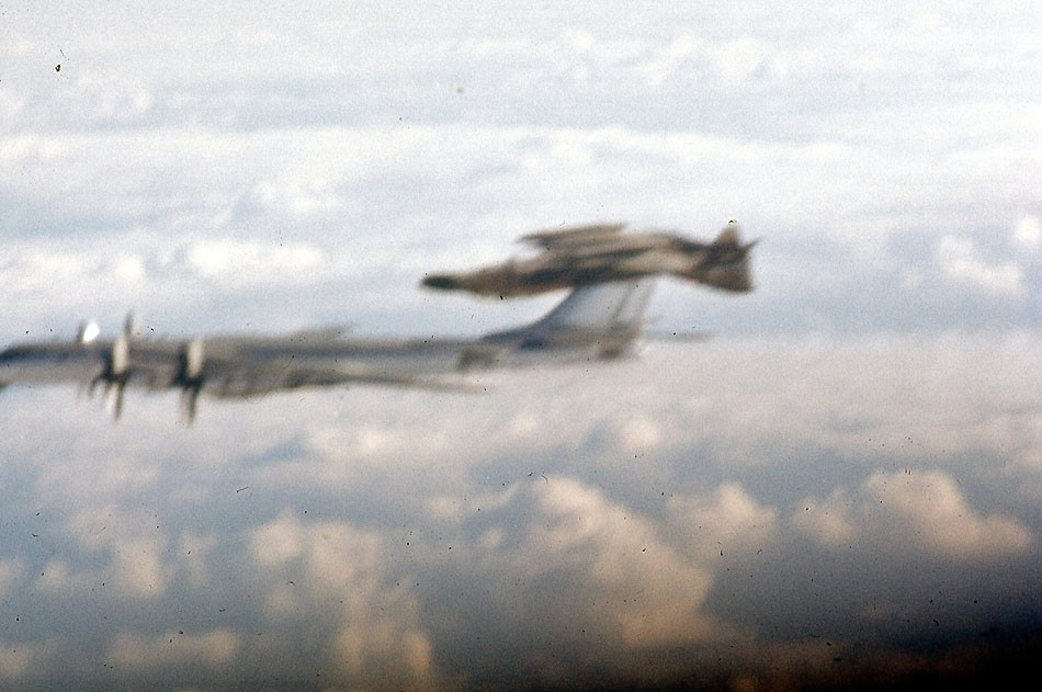 Sovietsky bombardér Tu-95 Bear a tesne nad ním pri výkrute americká stíhačka McDonnell F-4 Phantom II.