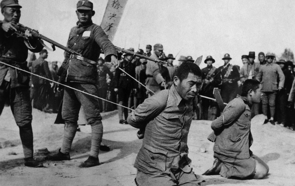 Japonskí vojaci pri poprave zajatých Číňanov v Nankingu v decembri 1937.