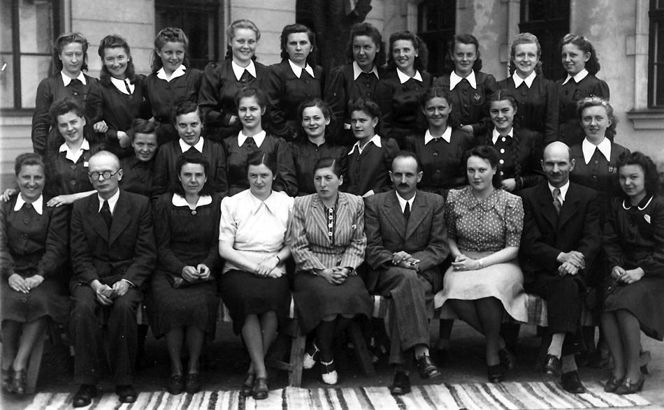 Krista Bendová (v strednom rade tretia sprava) so spolužiačkami a profesormi Štátneho slovenského	dievčenského gymnázia v Banskej Bystrici v roku 1941.