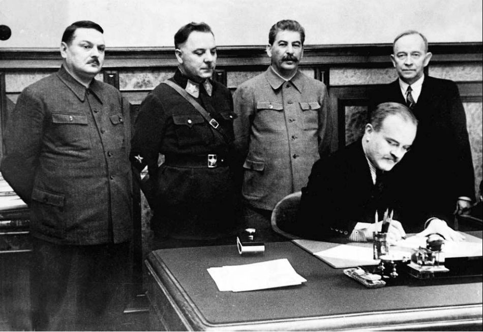 Sovietsky minister zahraničných vecí Vjačeslav Molotov pri podpise Moskovského mieru. Za ním stoja zľava Andrej Ždanov, Kliment Vorošilov, Josif Stalin a Otto Ville Kuusinen.