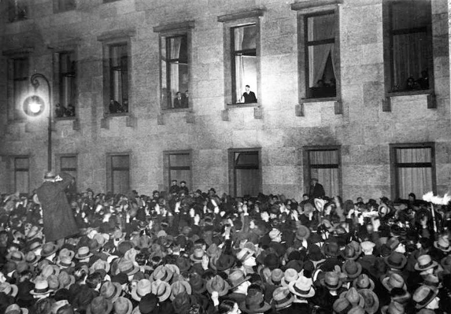 Hitler zdraví 30. januára 1933 večer svojich prívržencov z okna ríšskeho kancelárstva. Nacisti slávia triumf.