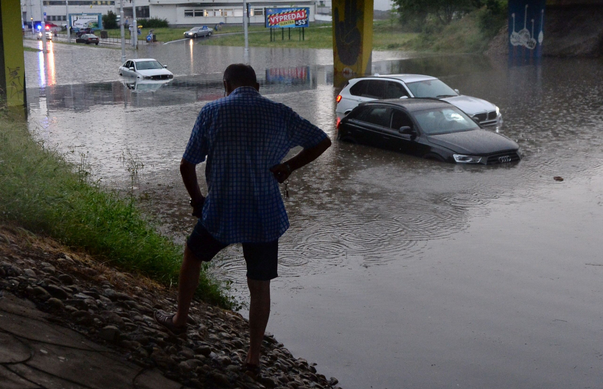 Na snímke bezmocný majiteľ utopeného auta na zaplavenej Ružinovskej ulici pod mimoúrovňovou križovatkou s Bajkalskou ulicou v Bratislave