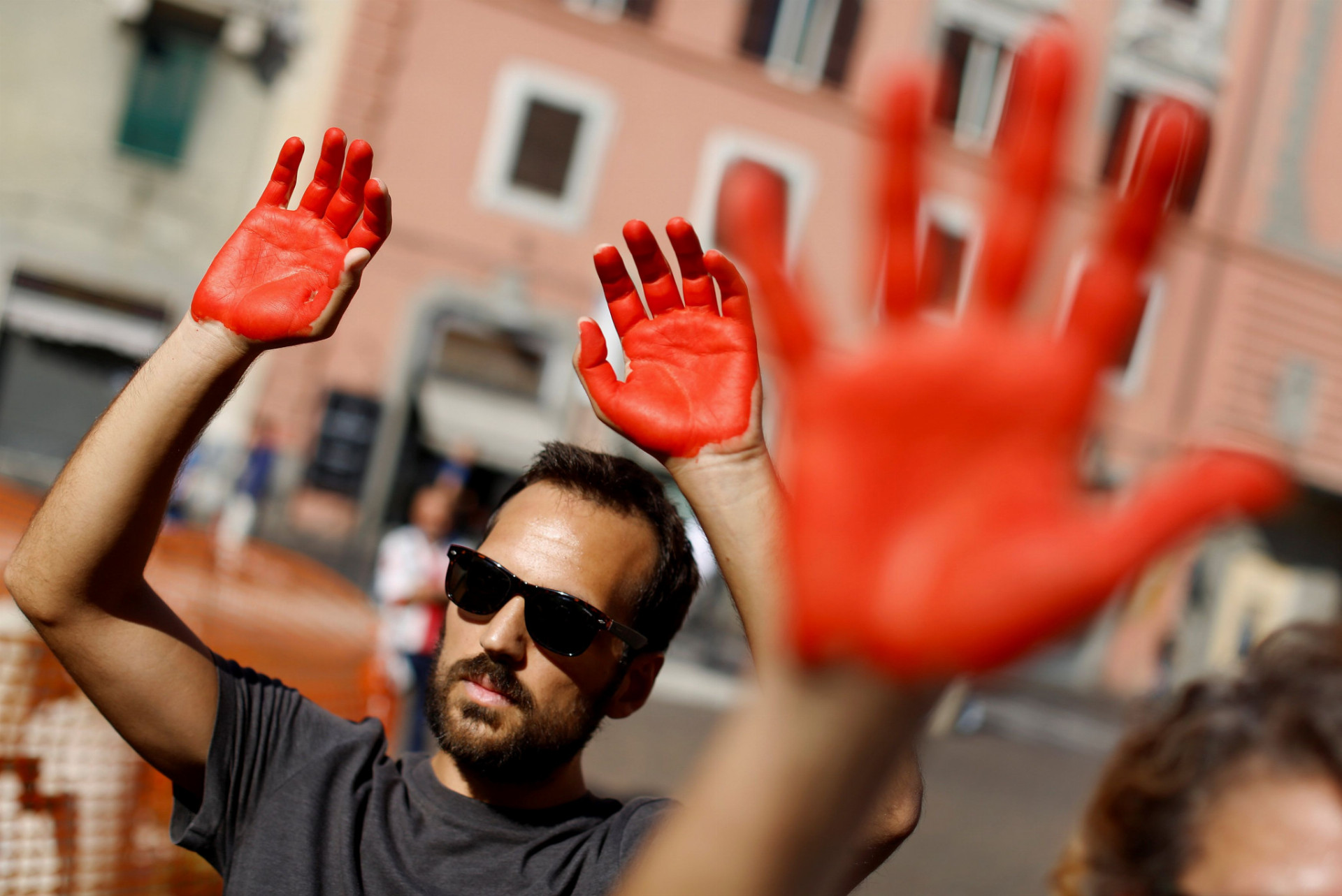 Na protest proti nominácii Mattea Salviniho si talianski aktivisti pomaľovali ruky na červeno.
