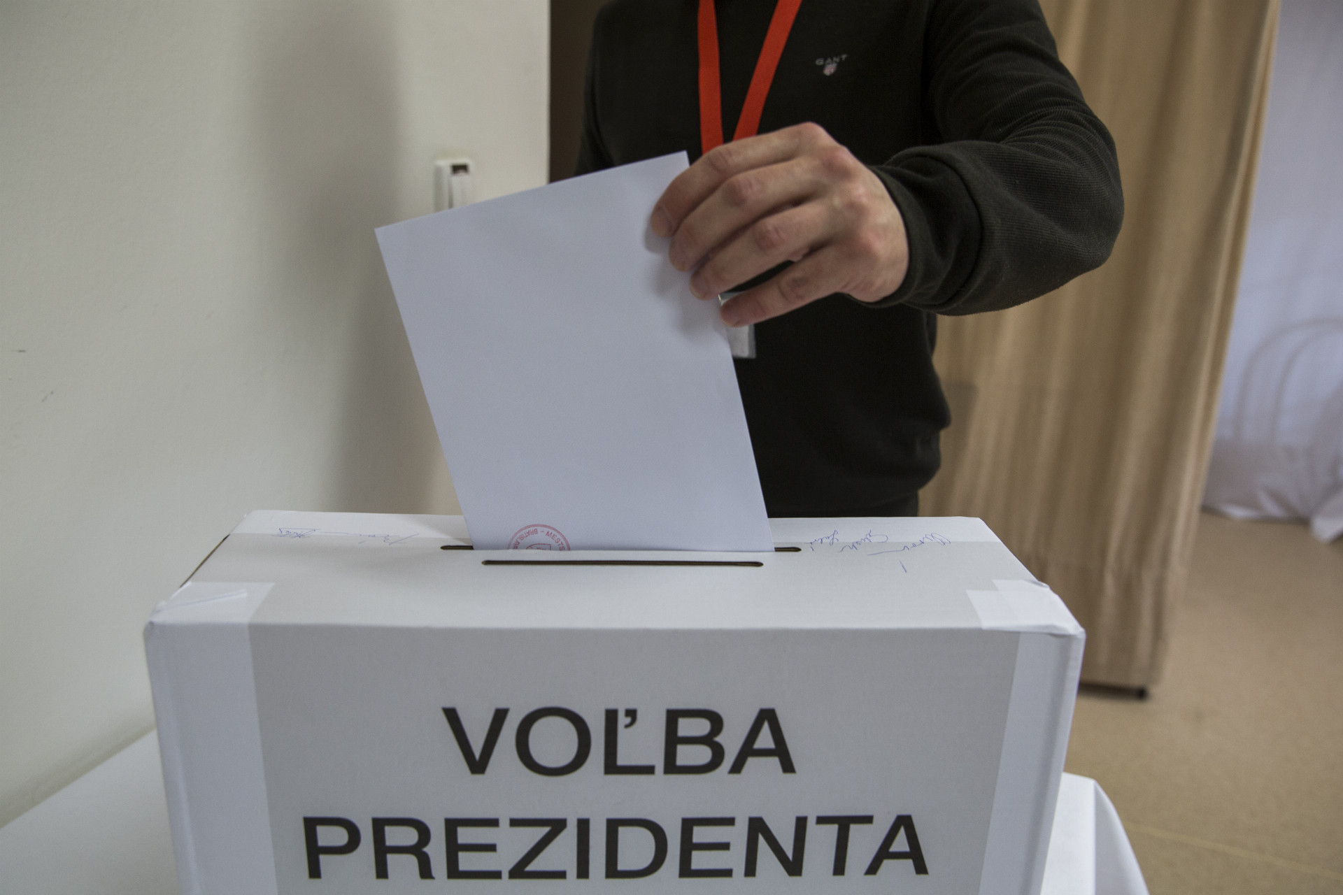 Na snímke volič vhadzuje obálku s hlasovacím lístkom do volebnej schránky počas 1. kola prezidentských volieb na otvorenom oddelení v Ústave na výkon väzby a Ústave na výkon trestu odňatia slobody v Bratislave.