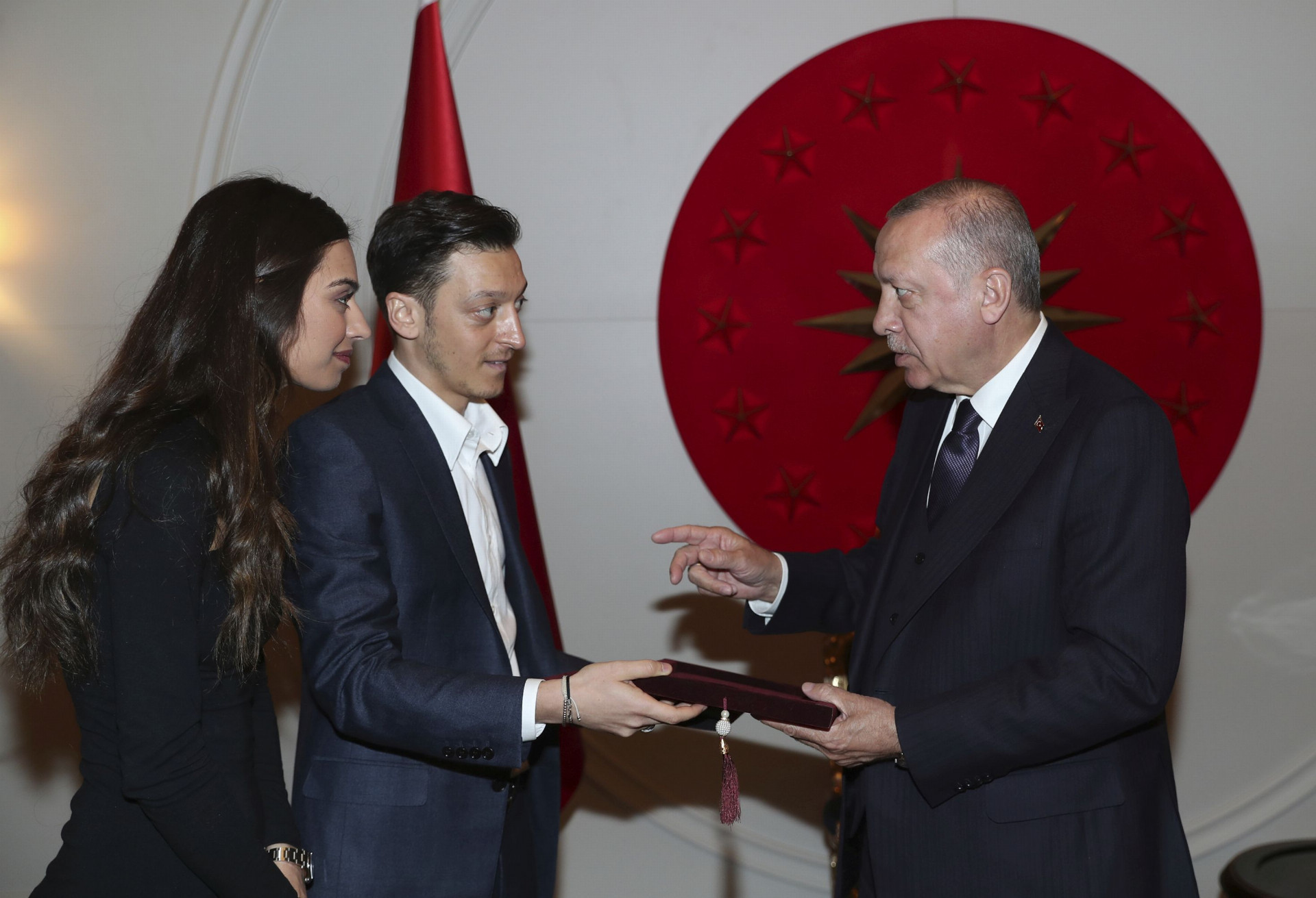 Turecký prezident Recep Tayyip Erdogan (vpravo) dostáva pozvánku na svadbu od nemeckého futbalistu tureckého pôvodu Mesuta Özila (uprostred) a jeho snúbenice Amine Gülşeovej v Istanbule.