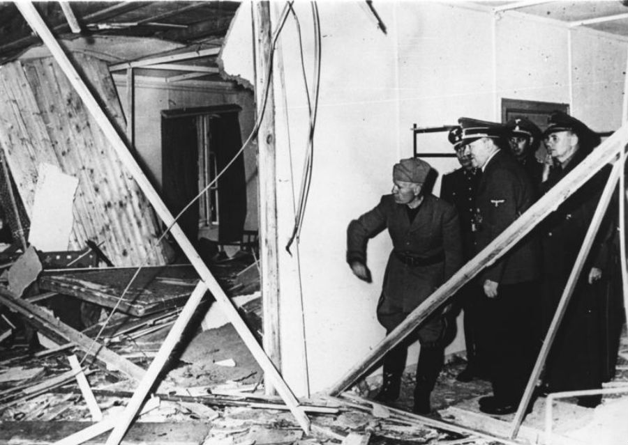 Adolf Hitler ukazuje Benitovi Mussolinimu zničenú miestnosť v bunkri, kde naňho 20. júla 1944 spáchali atentát.