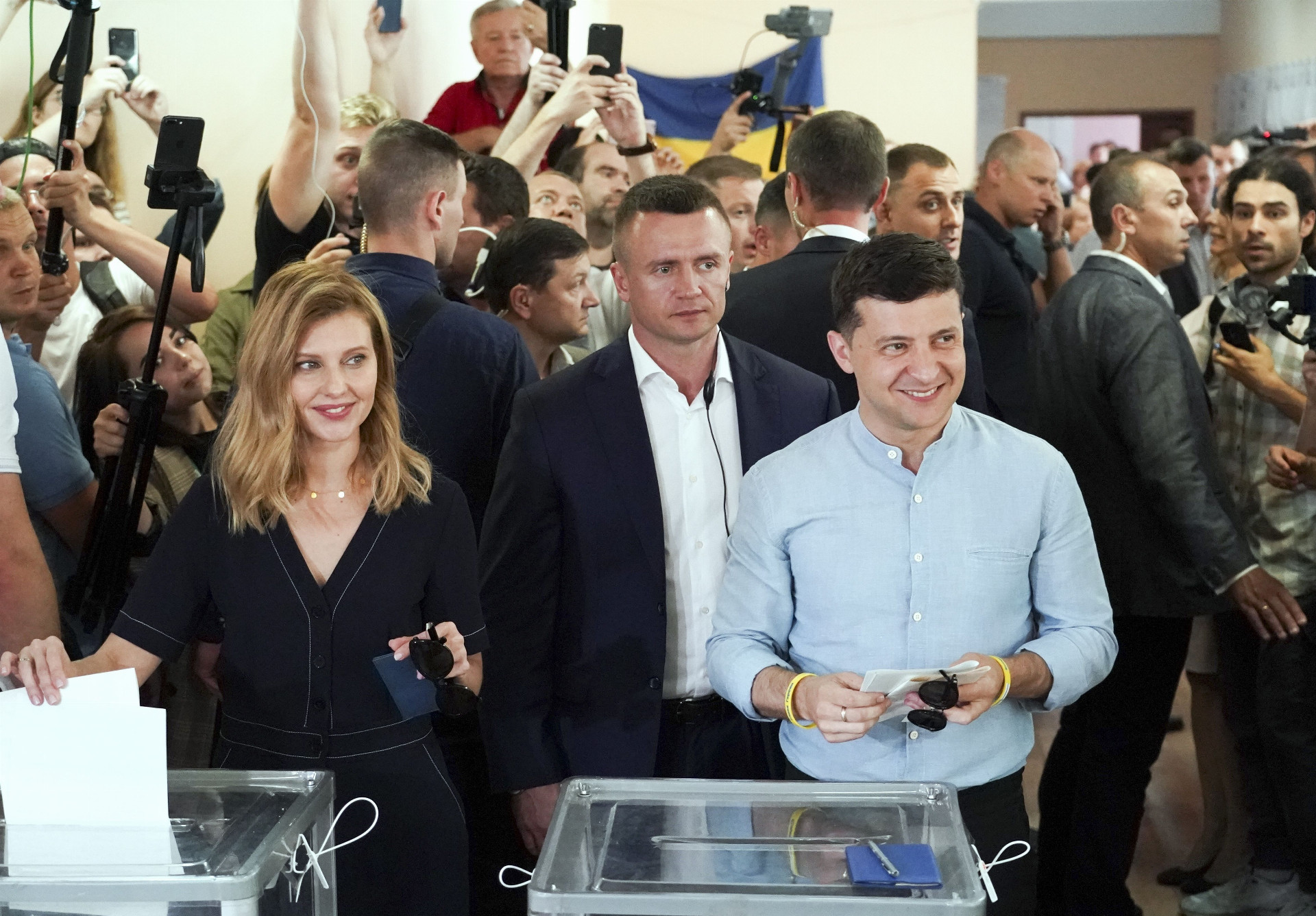 Ukrajinský prezident Volodymyr Zelenskyj (v popredí vpravo) prišiel hlasovať v parlamentných voľbách s manželkou Olenou.