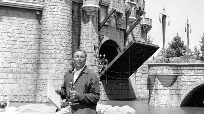 Walt Disney sedí na kameni pred hradom Šípkovej Ruženky v kalifornskom Disneylande v roku 1955.