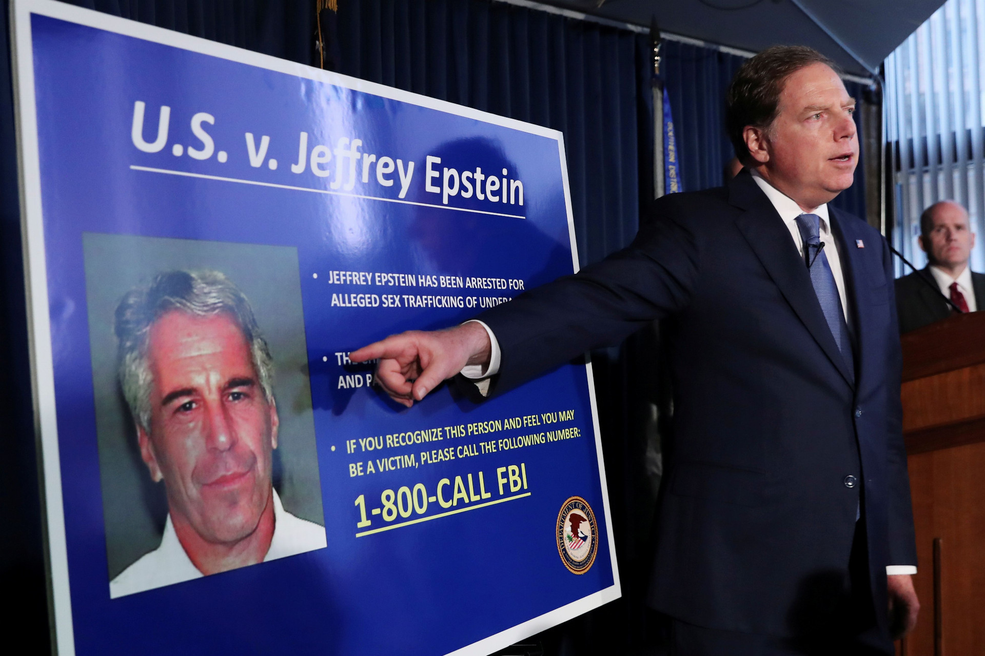 Prokurátor ukazuje podobizeň Jeffreyho Epsteina, ktorý je ústrednou postavou pedofilného škandálu, do ktorého majú byť zapletené americké elity.