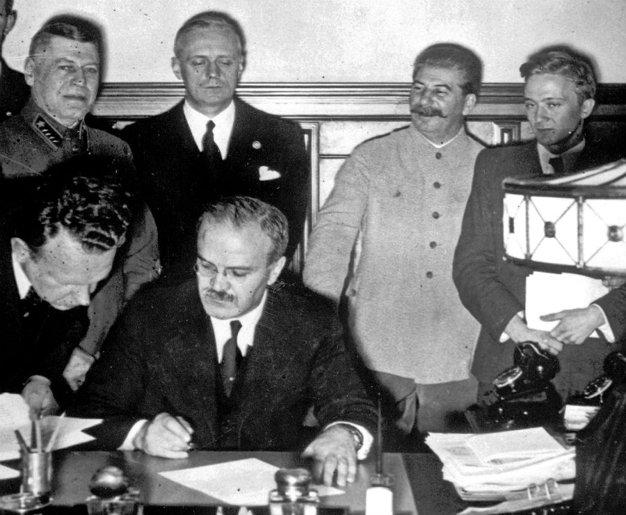 Sovietsky minister zahraničných vecí Vjačeslav Molotov podpisuje 23. augusta 1939 pakt o neútočení s Nemeckom. Za ním stojím (v tmavom obleku, po Stalinovej pravej ruke) jeho nemecký náprotivok Joachim von Ribbentrop. O tajnom dodatku zmluvy, ktorou si obe krajiny rozdelili Poľsko, sa svet dozvie oveľa neskôr.