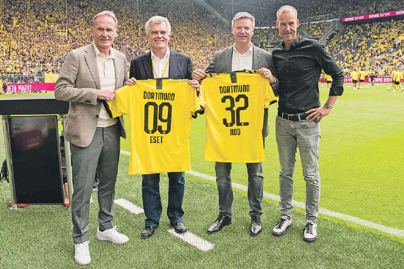 CEO Borussie Dortmund Hans-Joachim Watzke a spoluzakladateľ spoločnosti Eset Anton Zajac (prvý a druhý zľava) pózujú počas oficiálneho predstavenia spolupráce na domácom štadióne slávneho nemeckého klubu.