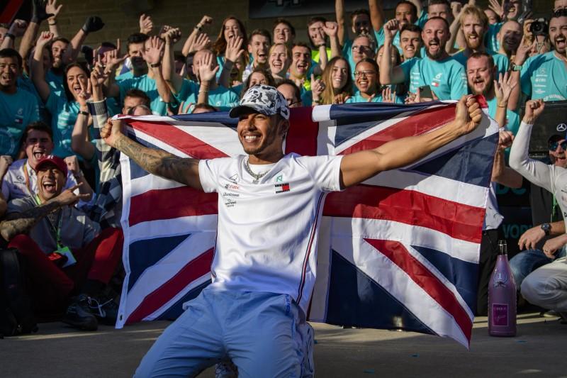 Čerstvý majster sveta F1 Lewis Hamilton sa teší zo zisku titulu spolu so svojím početným podporným tímom.