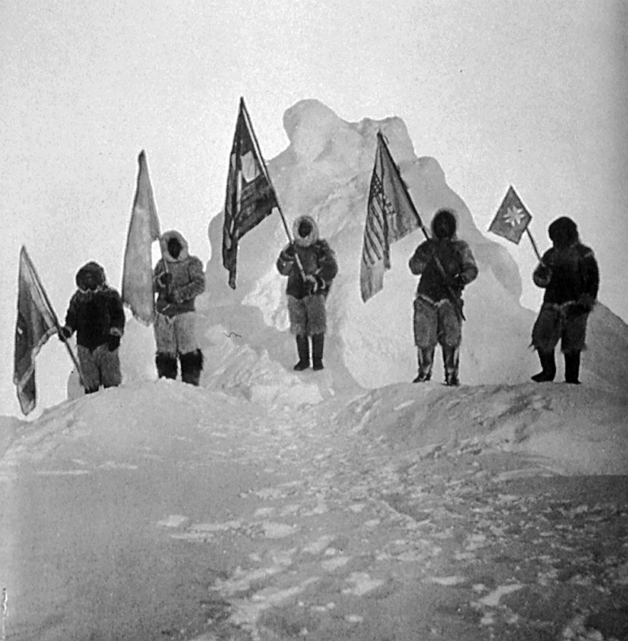 Členovia Pearyho sprievodu - štyria Eskimáci a jeho černošský sluha Henson - pózujú niekoľko kilometrov od údajného severného pólu s vlajkami. Polárnik na snímke nie je, pretože ich fotografoval.