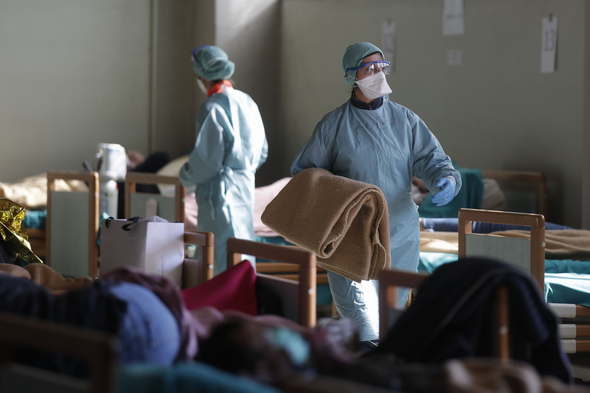 Pacienti ležia na lôžkach v jednej z improvizovaných miestností v nemocnici v meste Brescia v Taliansku 
