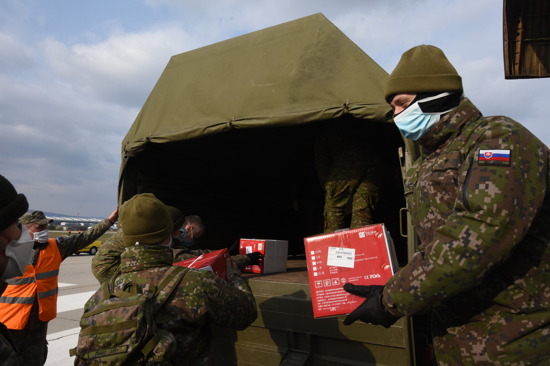 Slovenskí vojaci vykladajú zdravotnícky materiál z Číny