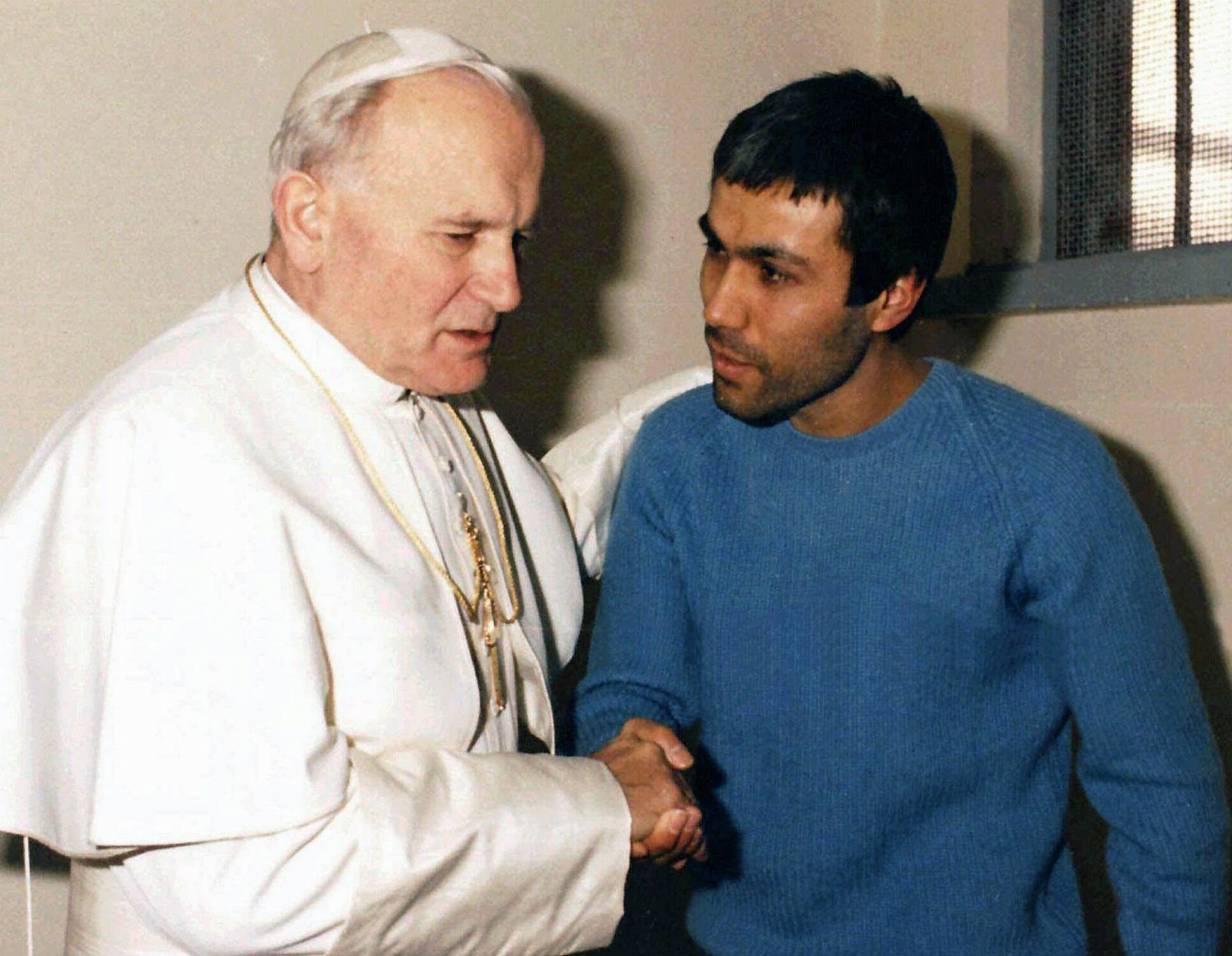 Pápež Ján Pavol II. si na snímke z roku 1983 podáva ruku s mužom, ktorý naňho spáchal atentát.