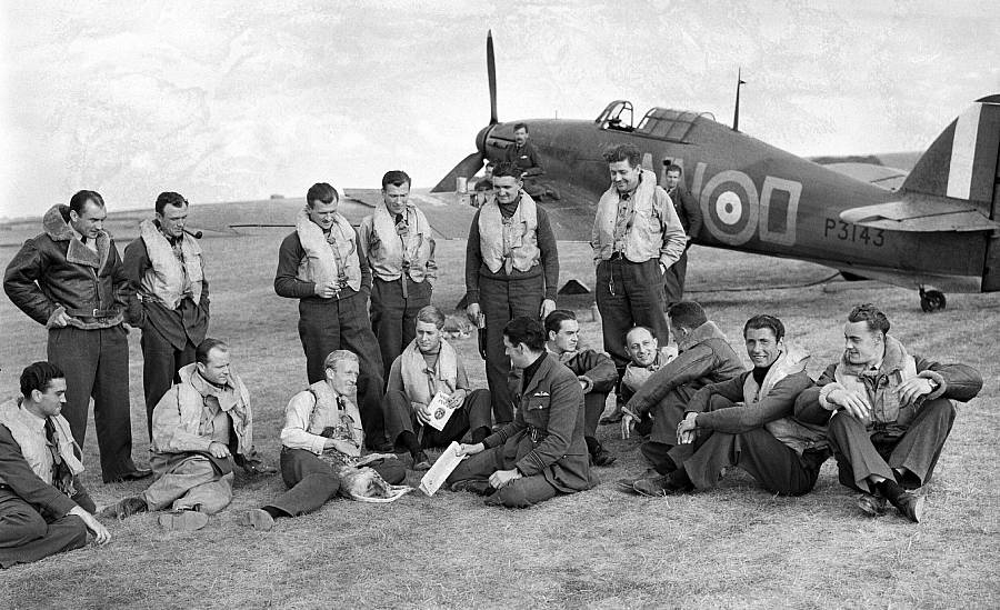 Príslušníci 310. (československej) perute RAF v období bitky o Britániu. V pozadí je stíhačka Hawker Hurricane.