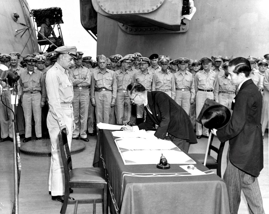 Japonský minister zahraničných vecí Mamoru Šigemicu podpisuje 2. septembra 1945 na palube lode USS Missouri dokument o bezpodmienečnej kapitulácii jeho krajiny.