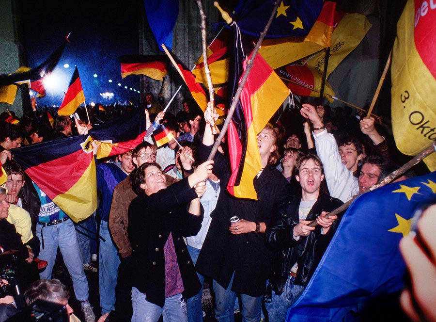 Ľudia oslavujúci zjednotenie Nemecka pri Brandenburskej bráne v berlíne 3. októbra 1990.