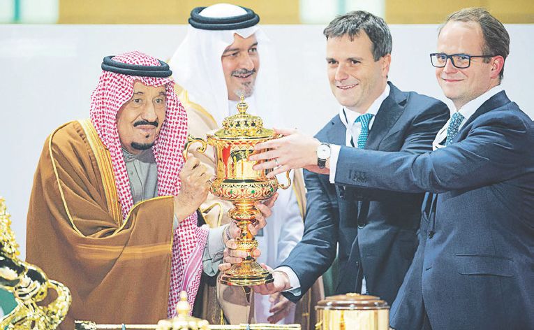 Saudský kráľ Salman pózuje s trofejou pre víťaza podujatia Saudi Cup. S prize money vo výške 20 miliónov dolárov ide o najlukratívnejšie preteky konských dostihov na svete.