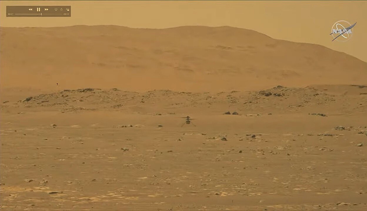 Snímka z kamery roveru Perseverance zachytávajúca let vrtuľníka Ingenuity na Marse.