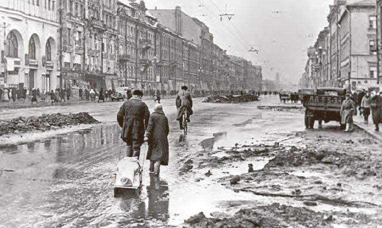 Život v obliehanom Leningrade. Stretnút na ulici ludí, vezúcich na sánkach telo zosnulého príbuzného, nebolo v zime nic výnimocné. Rovnako bežné bolo, že v továrnach, v tomto prípade pri výrobe zbraní, pracovali deti.