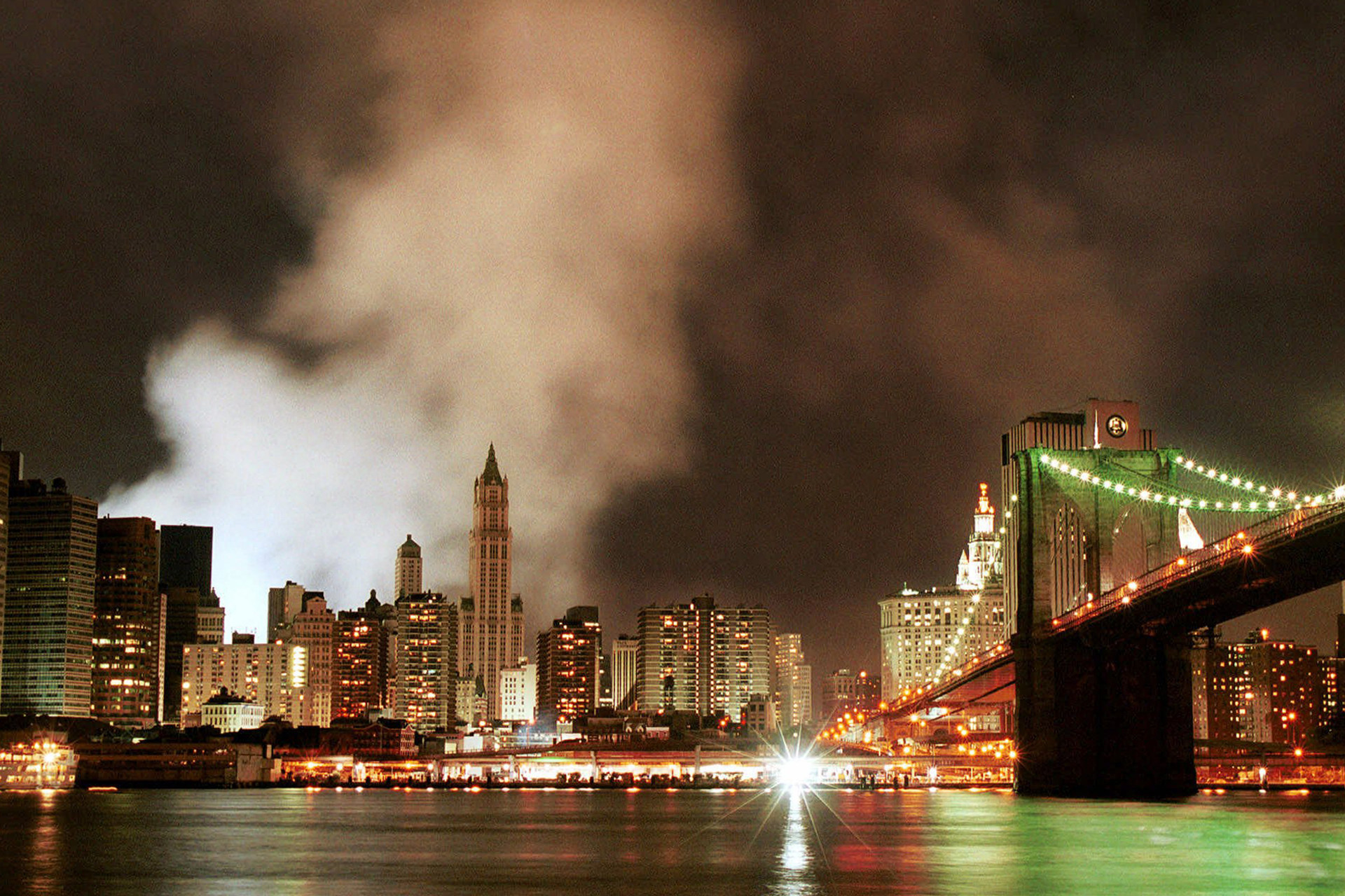 Dym stúpa z pozostatkov Svetového obchodného centra, vpravo Brooklynský most