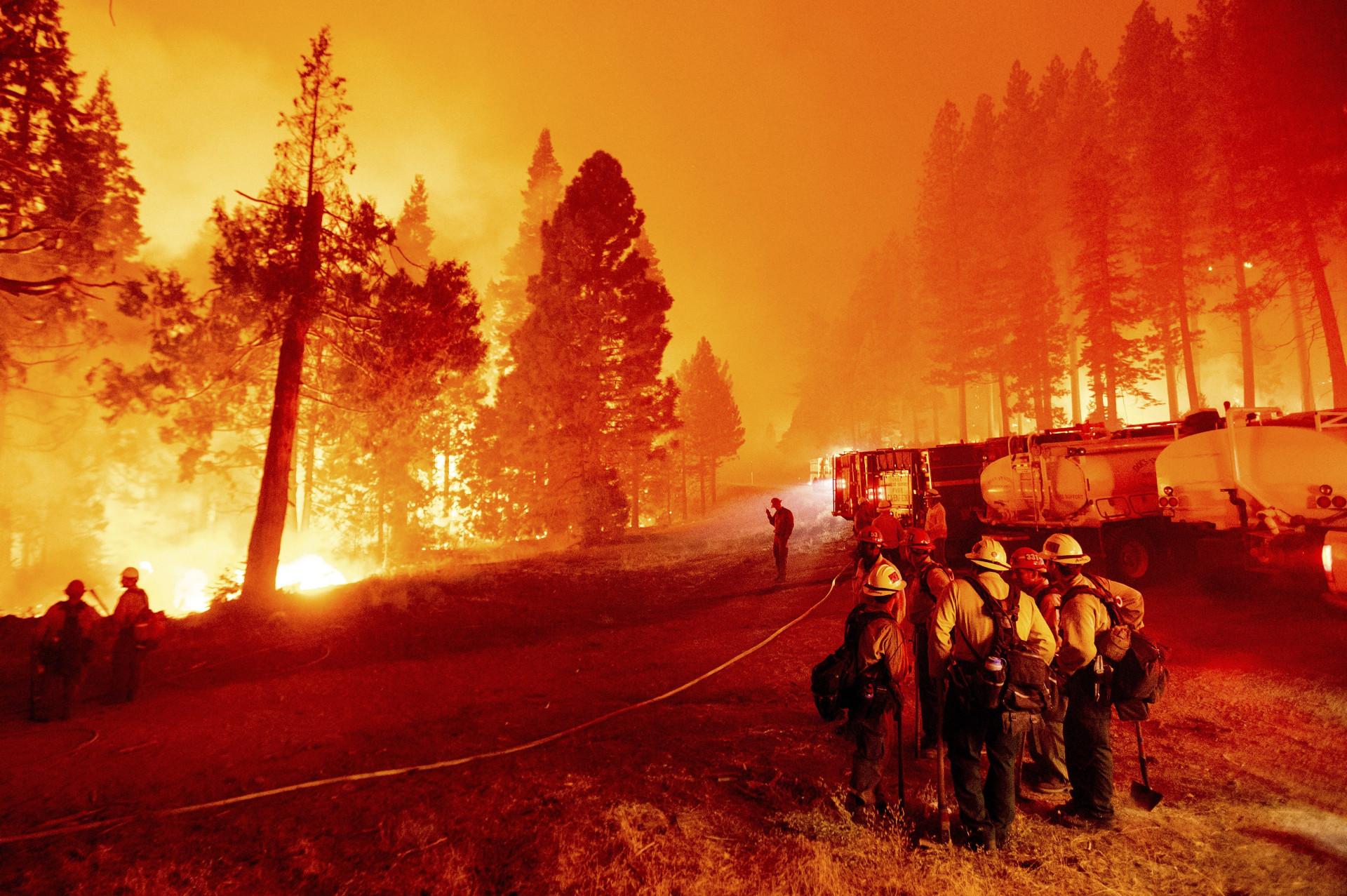 Hasiči bojujú s ohňom počas lesného požiaru v Národnom lese Eldorado v Kalifornii 26. augusta 2021 