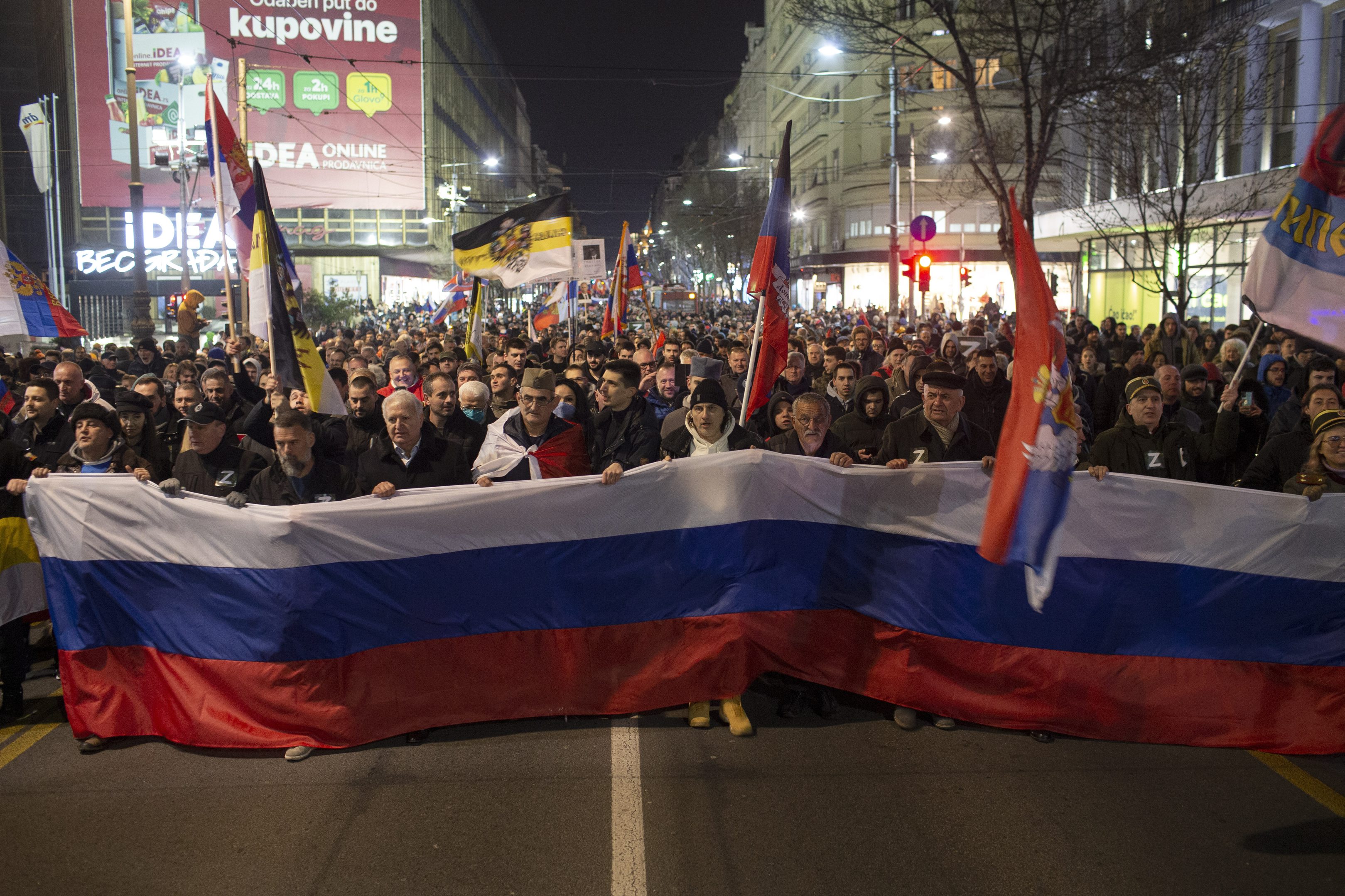 Demonštranti držia obrovskú ruskú zástavu počas protestného zhromaždenia na podporu Ruska v Belehrade