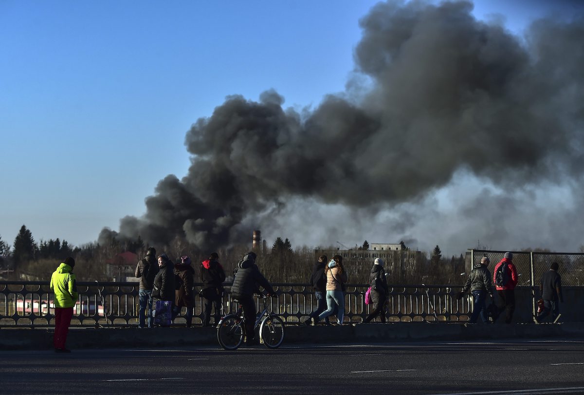 Ľudia sa pozerajú na dym po výbuchu v ukrajinskom meste Ľvov