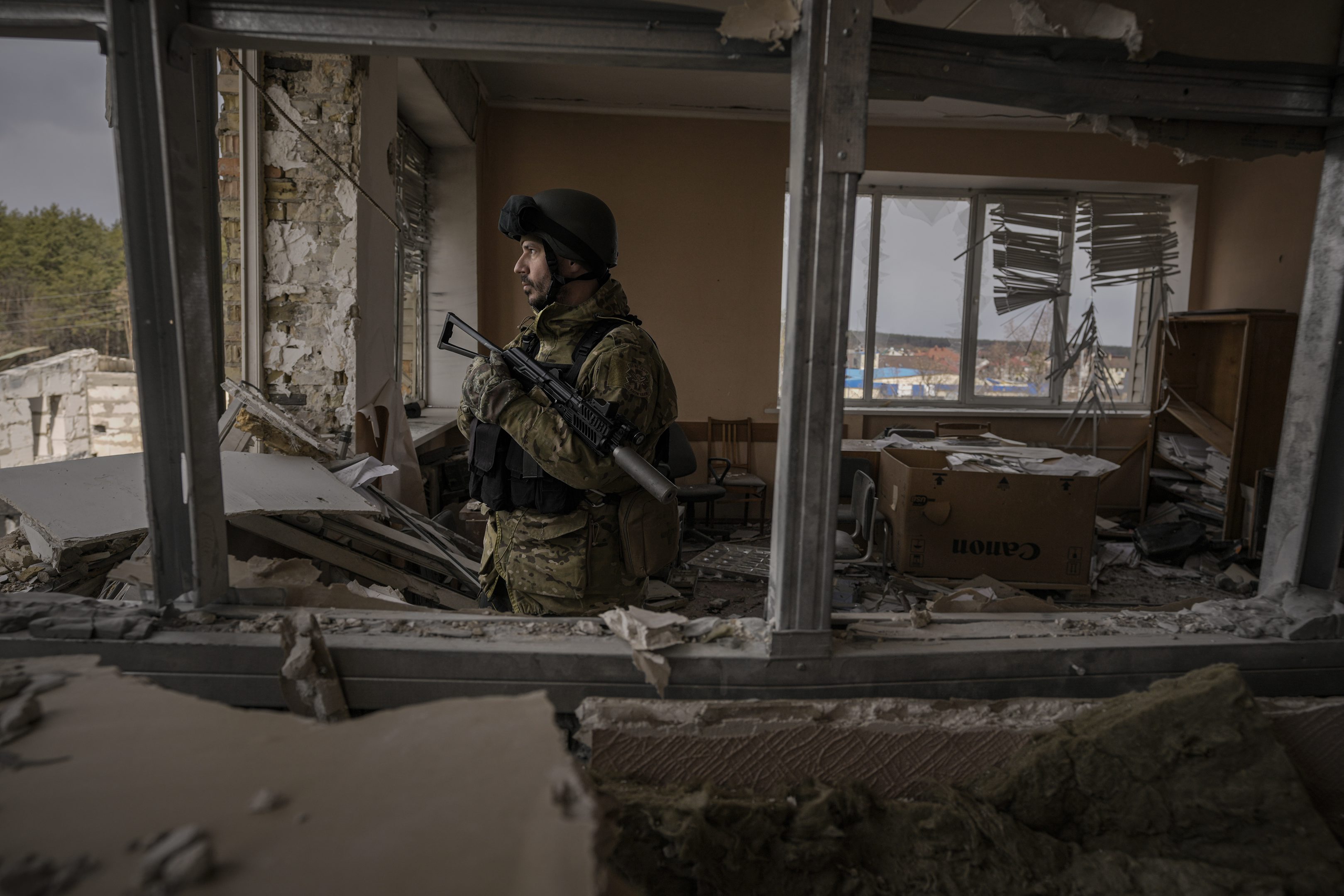 Ukrajinský vojak stojí v ťažko zničenej budove po ruskom ostreľovaní v meste Stojanka