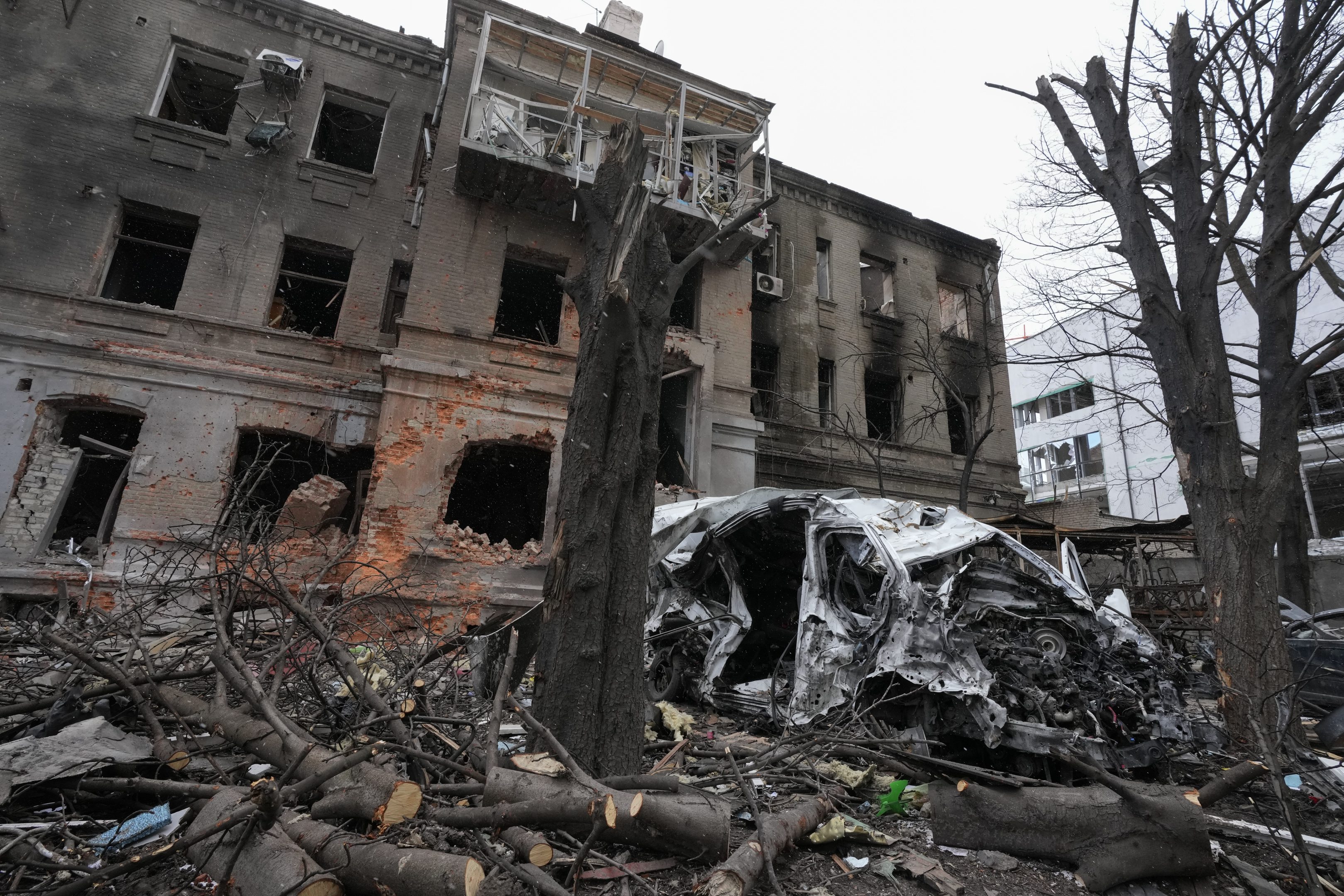 Zničená budova a auto po ruskom raketovom ostreľovaní v noci v centre Charkova