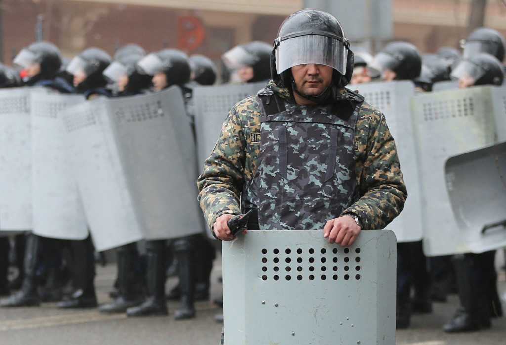 Kazašský policajt dohliada na bezpečnosť počas protestu vyvolaného zvýšením cien pohonných hmôt v Almaty.