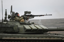 Člen posádky tanku ruských ozbrojených síl strieľa zo zbrane počas bojových cvičení na Kadamovskej strelnici v Rostovskej oblasti.
