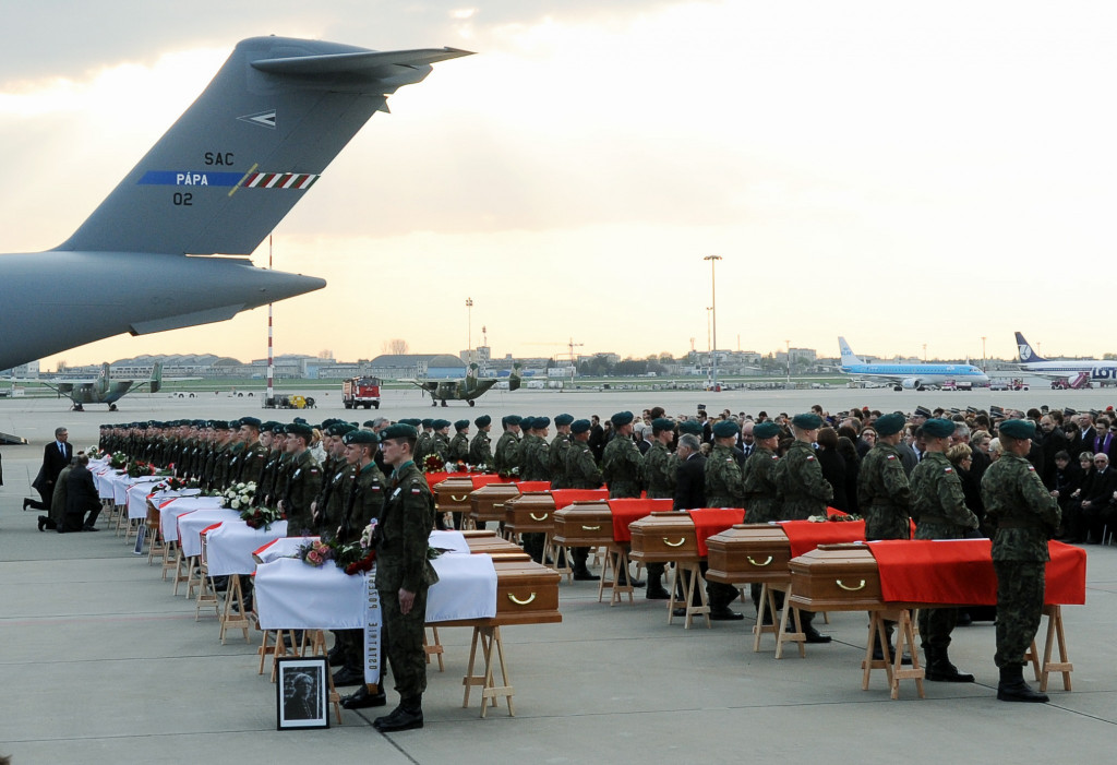 Vojaci poľskej armády stoja vedľa truhlí s telesnými pozostatkami ďalších 34 obetí leteckej katastrofy poľského prezidentského špeciálu pri Smolensku počas  ceremónie po prílete špeciálneho lietadla z Moskvy na vojenskom letisku vo Varšave 15. apríla 2010. Pri nehode vládneho lietadla Tupulev TU - 154 , ktoré sa zrútilo v sobotu 10. apríla 2010 pri pristávaní pri Smolensku , zahynuli poľský prezident Lech Kaczynski , jeho manželka Maria ako aj ďalší poľskí predstavitelia a popredné osobnosti spoločenského a duchovného života.