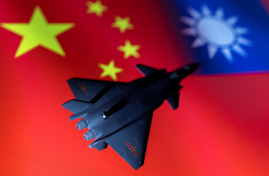Model čínskeho stíhacieho lietadla pred čínskou a taiwanskou vlajkou. FOTO: REUTERS/Dado Ruvic