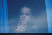 Dievčatko pozerajúce sa z okna autobusu počas evakuácie civilistov z oceliarní Azovstaľ v Mariupole. FOTO: REUTERS