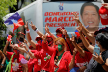 Priaznivci prezidentského kandidáta Ferdinanda „Bongbonga“ Marcosa mladšieho gestikulujú a oslavujú, keďže čiastkové výsledky hovoria o jeho úspechu.