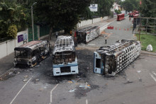 Zhorené vozidlá stúpencov vládnucej strany Srí Lanky sú vidieť po tom, čo boli podpálené počas stretu pro a protivládnych demonštrantov v blízkosti oficiálneho sídla premiéra v Kolombe.